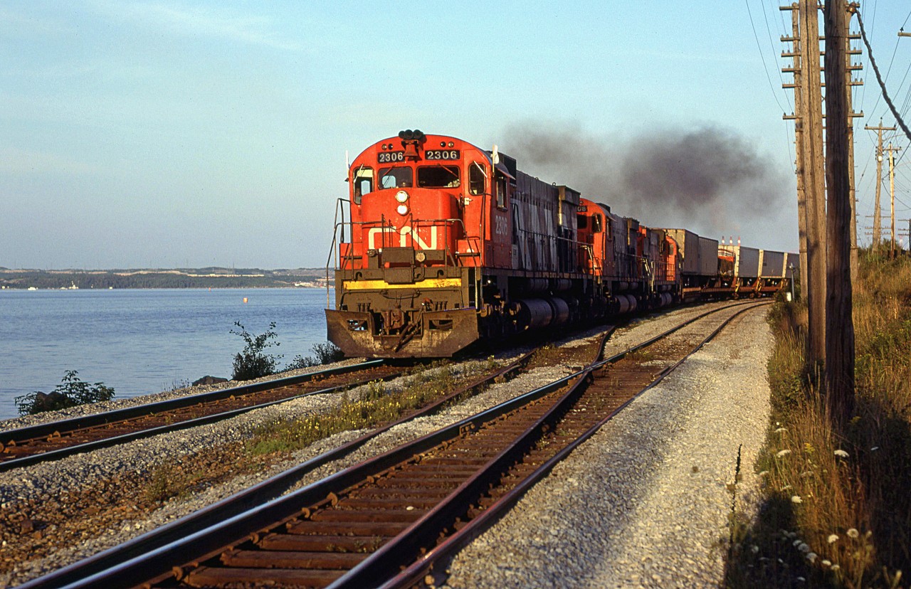 CN 205 accelerates out of Rockingham Yard into the setting sun. It is assembled the second part of the train at Rockingham and rounds Sherman Point. Bedford Basin and Dartmouth are seen in the background.