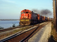 CN 205 accelerates out of Rockingham Yard into the setting sun. It is assembled the second part of the train at Rockingham and rounds Sherman Point. Bedford Basin and Dartmouth are seen in the background.