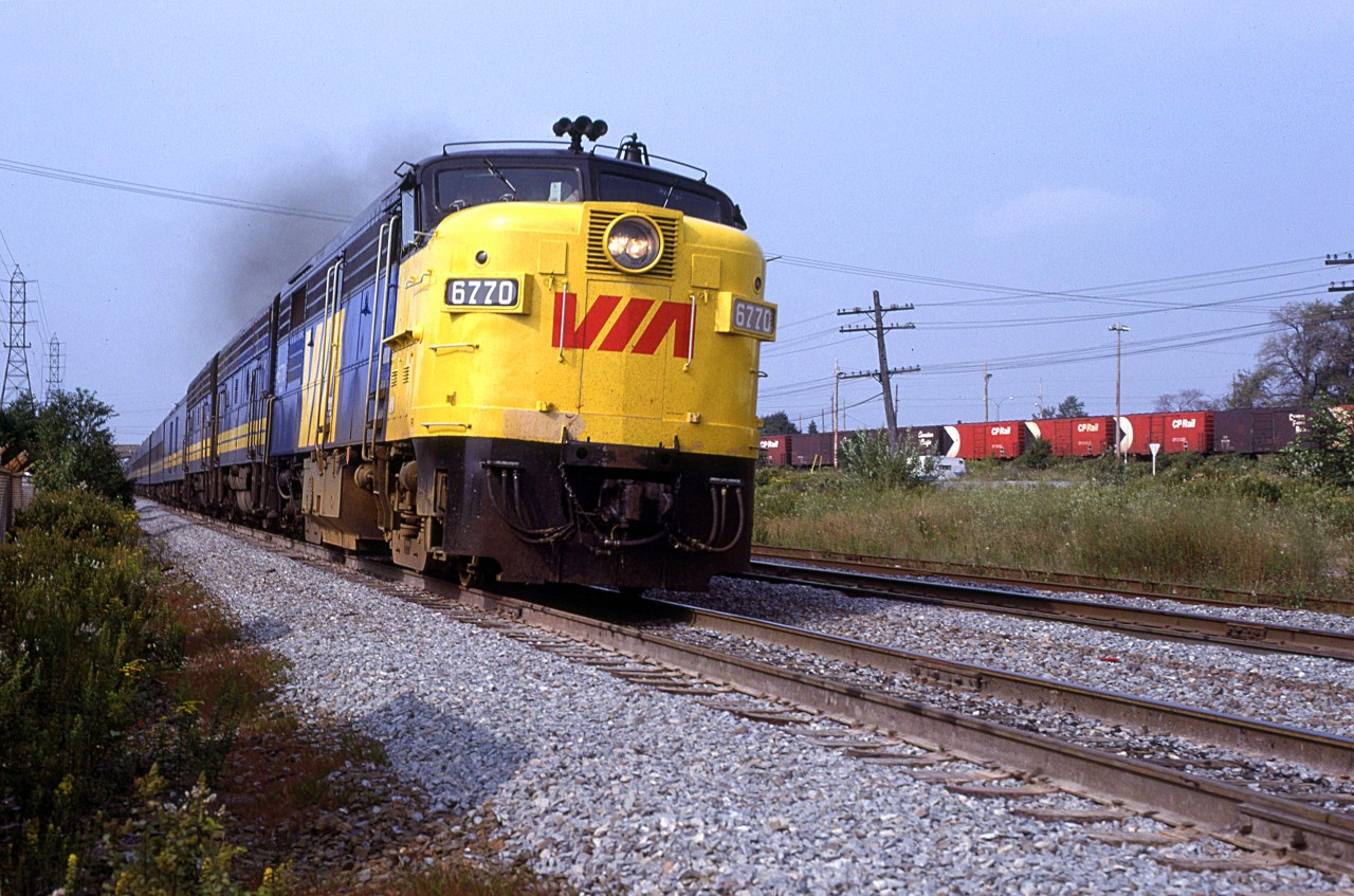 The clouds lifted by 1549hrs when the "Atlantic" arrived. 
The only remarkable aspect of this photo is that the lead unit it tilted rather dramatically indicating the beginning of the super-elevation of the curve at Armdale.
The CPR boxcars are at the Simpson-Sears warehouse and store.