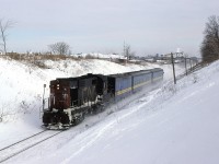 VIA 85 is kicking up the snow as it leaves the urban area of Kitchener. This is now a tree-lined ROW with sprawl reaching well beyond this point.