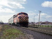 
After finishing up my work term in northern Quebec, I flew to my parent's place in Halifax. On a layover at Dorval, I stored my bags and went trackside for a short time. 
An eastbound (inbound) commuter train, running on the CPR zips past the Dorval platform, visible at the rear of the train.
