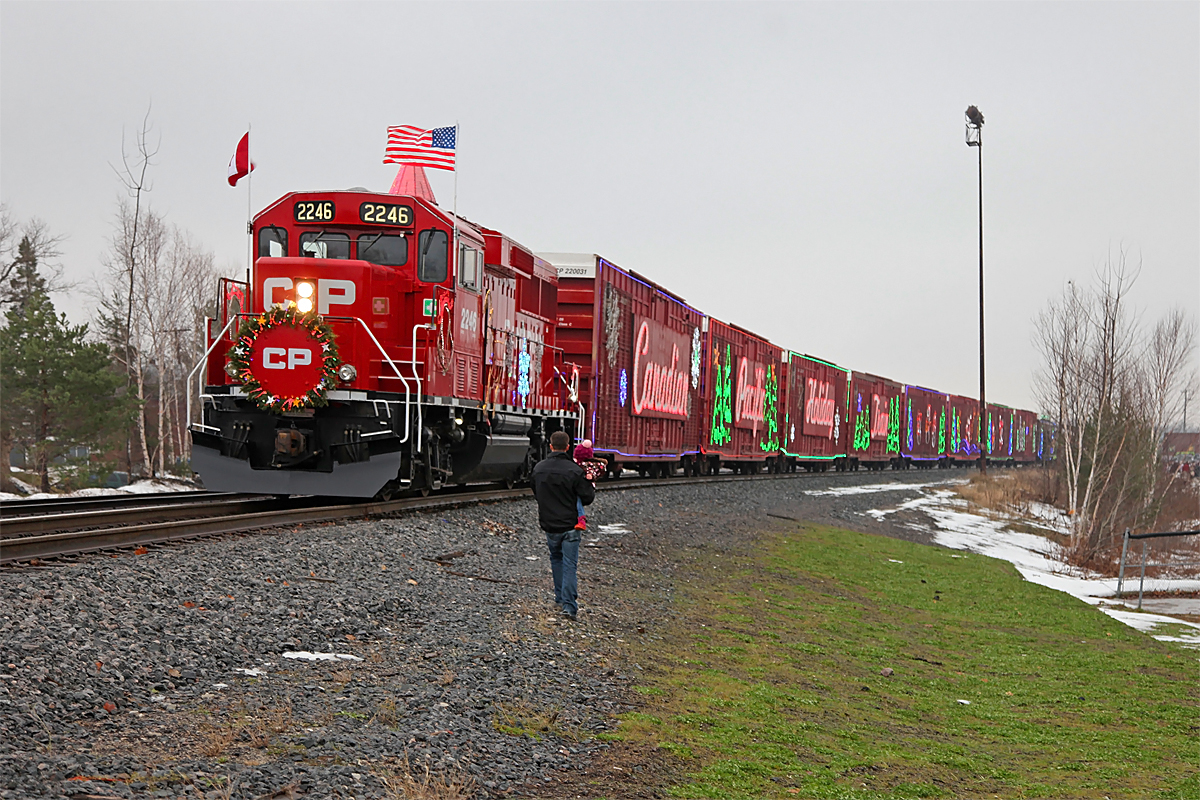 A father introduces his young daughter to the motive power of the 2014 CP Holiday Train while stopped in MacTier, readying for its performance on a soggy and grey November afternoon.