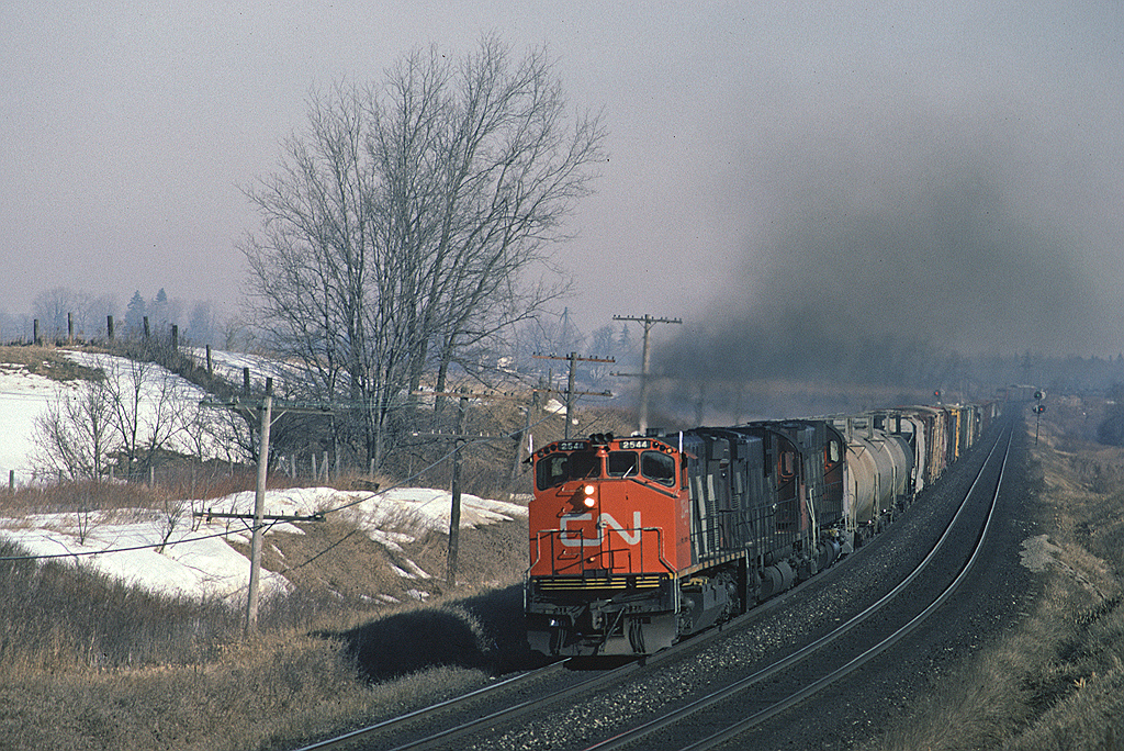 A trio of MLWs on #393 was not unusual in 1987 but an M420W leading was different. CN 2544 is smoking it up with #393 with a pair of six-axle MLWs trailing as they approach Brantford.