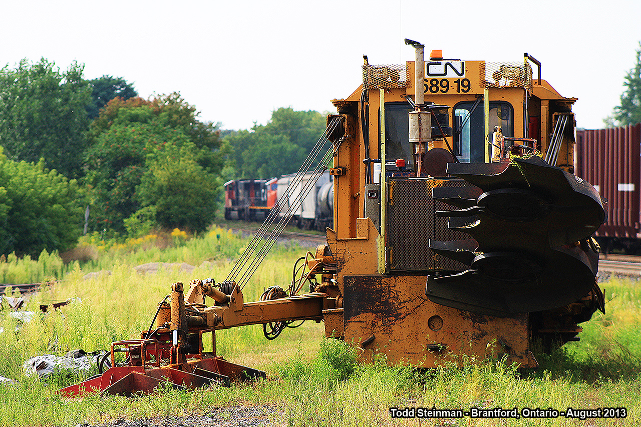 Sometimes, when photographing - you just never know what you will find in or around the railway yard. Here on this warm August evening, CN 68919 - a grass cutter / weed removing maintenance of way equipment, sits peacefully on a siding at Brantford. In the distance, just visible is CN 5752, CN 5692 and another CN unit. They are just completing a swap of cars in the Brantford yard, and will soon re-couple onto the rest of their train and depart Brantford.