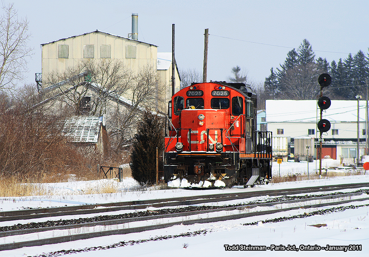 Dimunitive CN 7025 rolls in from Brantford onto what used to be the Harrisburg Subdivision - but is now the north siding at Paris Junction. Paris Junction was once a busy place, and by today's standards of railroading it still is. But industries have closed - the buildings in the background...some were old facilities for Paris Kitchens, and the remaining buildings were once used for manufacturing businesses that would ship their product by rail. However, on this cold wintry day in January, it was just as cold for photography. Not too much action aside from little old 7025 coming to assemble some of it's manifest and haul it back to the Brantford yard.