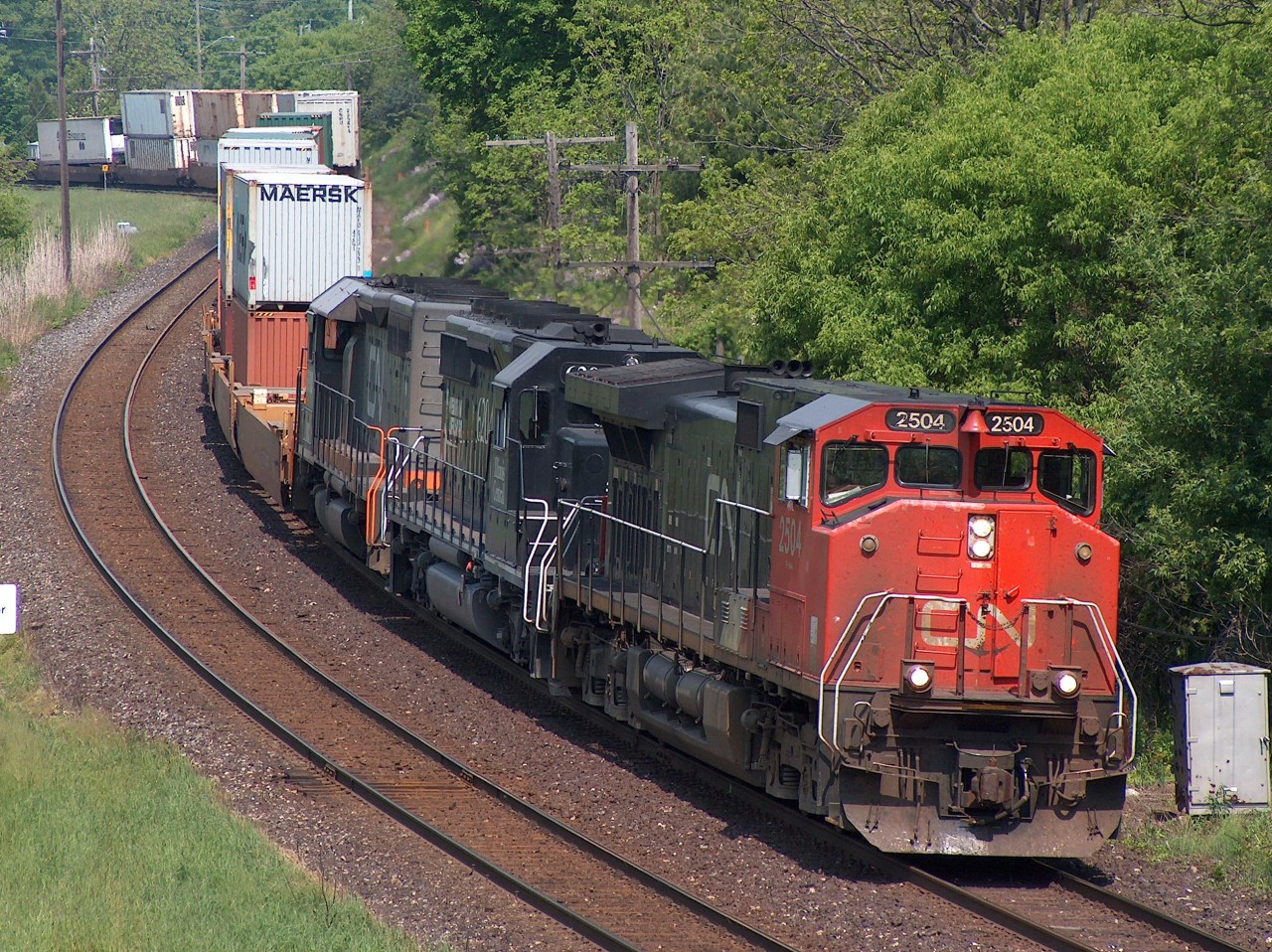 CN 148 with wide cab CN 2504 leading an IC unit, and one of those WC reporting marked grey with orange striped CN units that were commonplace back in 2006, eases around the curves through Paris on May 28, 2006.