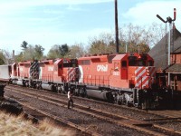 Greetings exchanged between engineer and one of the local maintenance guys as CP 5663 West (I always refer to them as "North" thru here)slows up as flimies are about to be handed up as the caboose passes. Power on this train is CP 5663, 5908 and 5974. One of the things I loved about hanging out at the station was the freedom to cross the tracks at will. And for morning northbounds, this was the very best place for sun angle as the northbounds came off the trestle turning abruptly eastward for a half mile before the tracks turned north again.