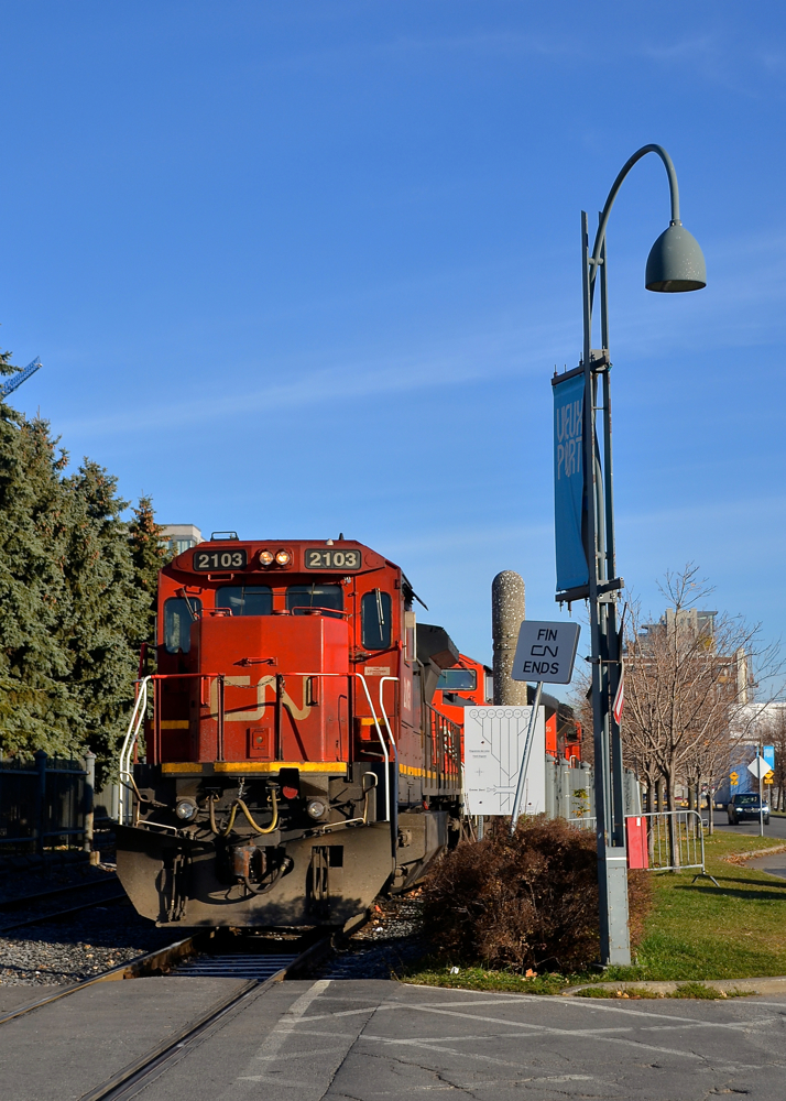 CN ends. The sign beside CN 2103 says 'CN ends' in French and English, as this is where the CN Wharf Spur ends and the Port of Montreal's tracks begin. CN 2103 is leading CN 149 which is just inches away from being on CN tracks. It will leave in about 20 minutes, on its way to Chicago with high priority intermodal from the harbour.