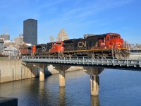 <b>A standard cab leader for once.</b> Standard cab C40-8 CN 2103 is leading CN 149, a nice change from the widecab ES44AC's which are now power for this train most of the time. Here CN 149 crosses the Lachine canal with high priority intermodal from the harbour. Trailing is CN 8876 & CN 8855.