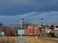 <b>Dark clouds looming.</b> CN 324 has a pair of NS Dash9's (NS 9008 & NS 9764) as it rounds a curve in the St-Henri neighbourhood of Montreal just as the sun comes out.