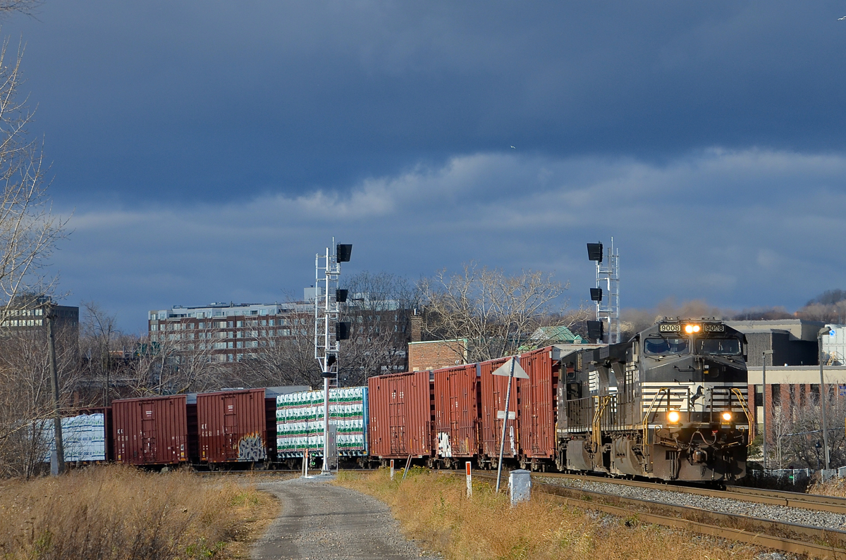 Dark clouds looming. CN 324 has a pair of NS Dash9's (NS 9008 & NS 9764) as it rounds a curve in the St-Henri neighbourhood of Montreal just as the sun comes out.
