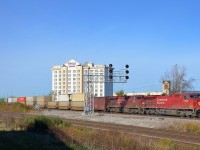 <b>Under a signal gantry.</b> CP 112 is eastbound through Dorval under a signal gantry. Power is repainted CP 9726 & CP 8703 with CP 8833 mid-train. At left is another signal gantry, on CN's Montreal sub.