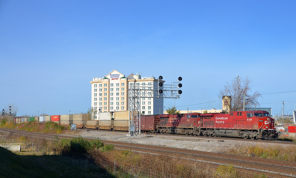 Under a signal gantry. CP 112 is eastbound through Dorval under a signal gantry. Power is repainted CP 9726 & CP 8703 with CP 8833 mid-train. At left is another signal gantry, on CN's Montreal sub.