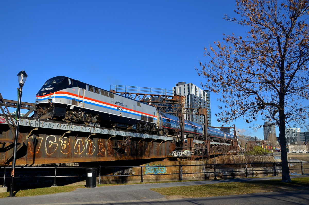 A heritage unit, back in town. For the second time in three days, AMTK 822 is on the southbound Adirondack out of Montreal. Here it backs up to Central Station before boarding passengers, as it crosses the Lachine canal.