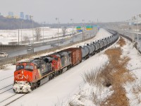 <b>Almost like a unit train.</b> CN 2278 & repainted BCOL 4618 lead CN 305 towards Turcot West where it will get a new crew. In the background at left is downtown Montreal and at right is the Turcot highway interchange. With so many tank cars at the head end, this looks like it could be a unit oil train.