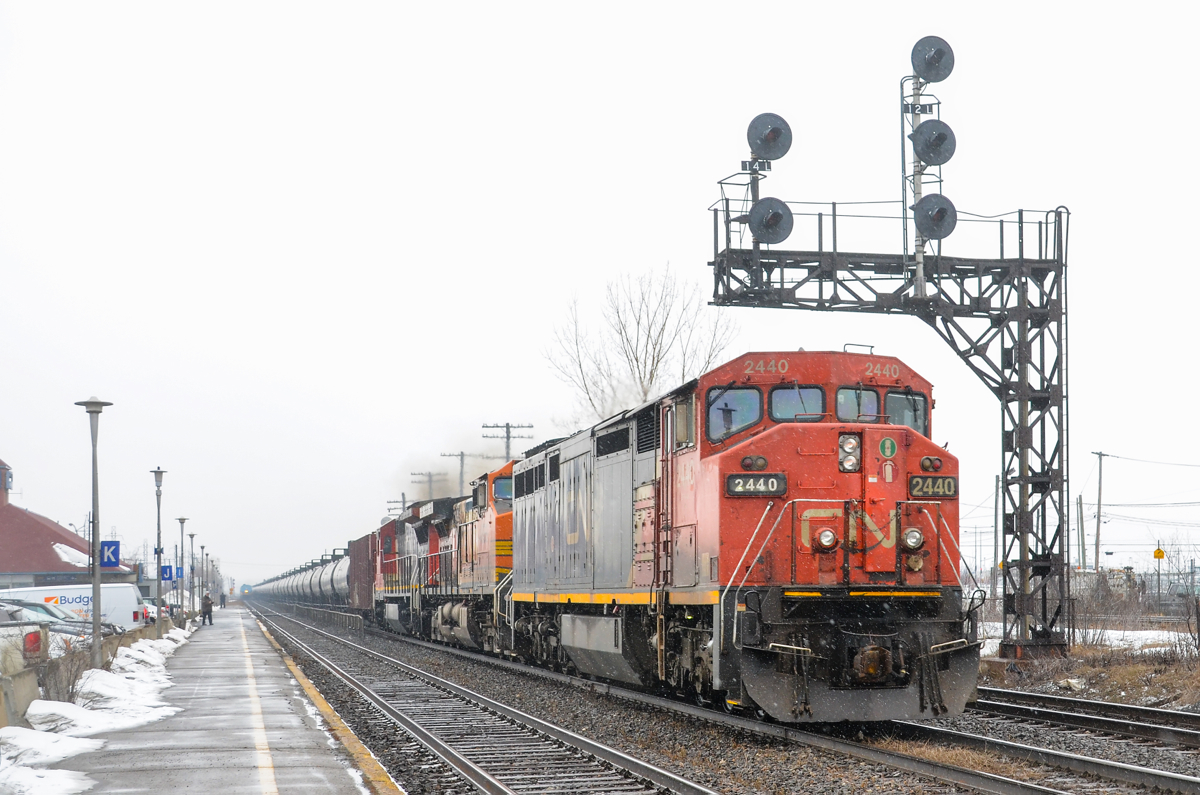 Loaded oil train CN 720 has a Dash8-40CM, Dash9-44CW and a Dash8-40C (CN 2440, BNSF 4869 & CN 2010) as it heads east through Dorval as a bit of snow falls.