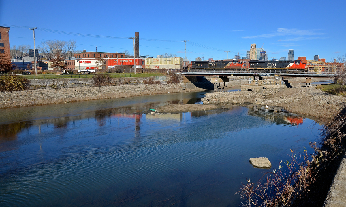 Stack train over the canal. CN 120 has CN 2866 & CN 8946 at the head end and CN 2842 operating mid-train on this nearly 14,000 foot long train, which is bound for Halifax. Here it is crossing the Lachine canal in Montreal.