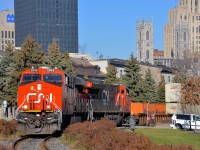 <b>CN 149 curving.</b> CN 2943 is in charge of CN 149 as it rounds a curve in the Port of Montreal, with CN 3023 trailing. In a few seconds the head end will cross the Lachine canal on a sunny fall morning. At right is a Port of Montreal employee flagging this crossing.