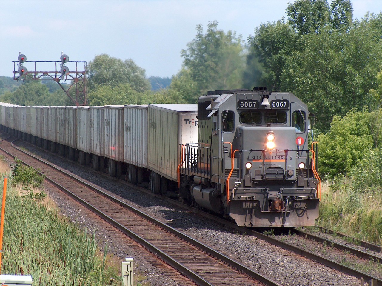 Since the Triple Crown service on CN has ceased, I thought I'd share this photo of CN 145 back in the summer of 2005. CN 145 cruises westward on the Halton Sub on a beautiful summer afternoon with a lone GEC Alstom locomotive on the point - GCFX 6067.