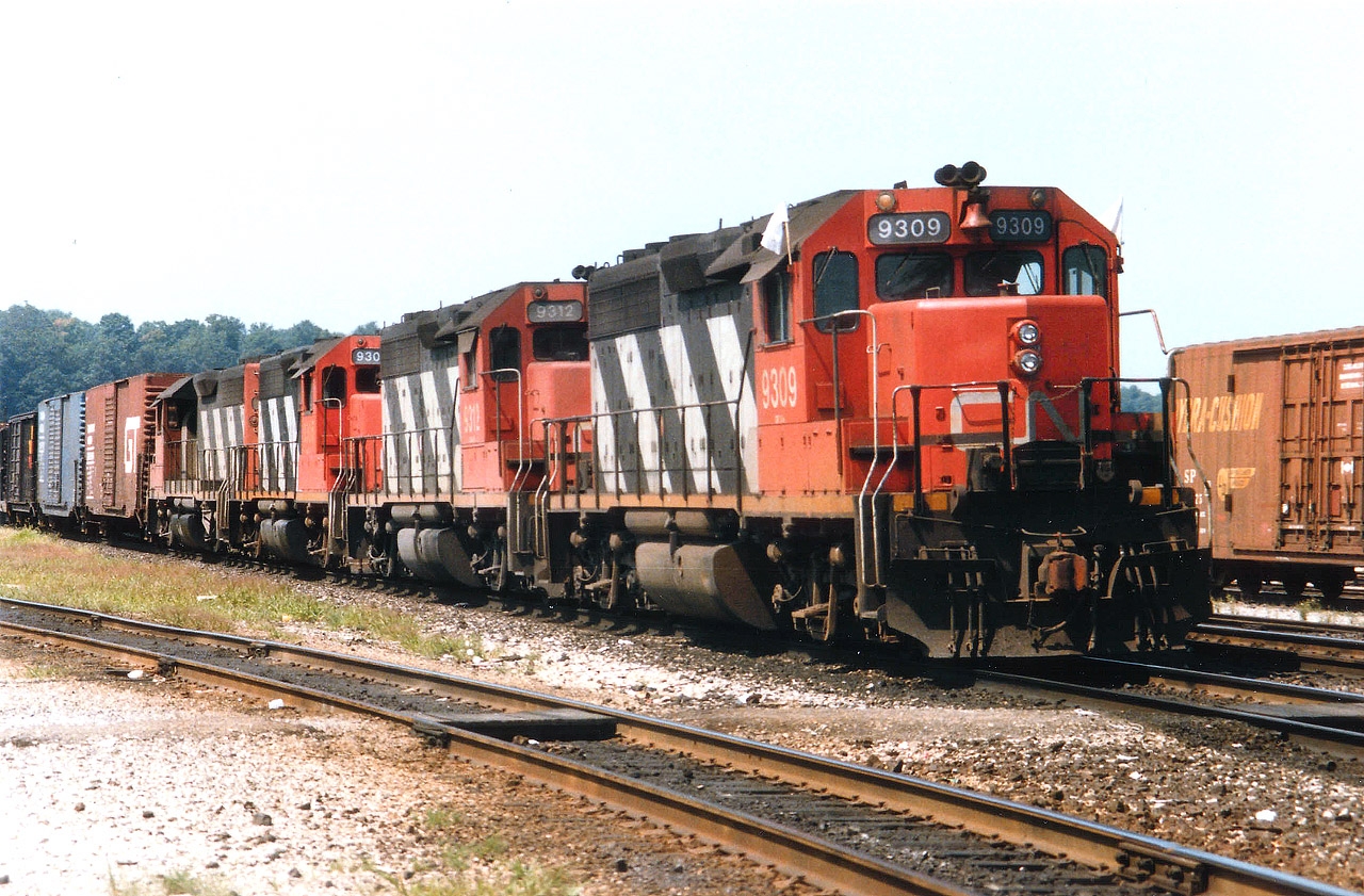 GP40s on CN on the roster as 4002-4017 were renumbered to 9302-9317 in 1981. The CTG shows no 9311. Does anyone know what happened to it? Wrecked as 4011??  Anyway, it was rather unusual to say the least that 4 of these units would unite to power one train. Pictured is CN 9309, 9312, 9305 and 9313 slowing to a stop in Hamilton yard on a run from Mac. Here, one of the units was set off so I did not follow the train down Niagara. The standard GP40s were all off the roster by 1998; the 9309 to RLK then retired; the 9305 to UP and most recent it is wandering as GMTX 2102. The 9312 and 9313 went to Roberval & Saguenay as their #'s 60 and 66.