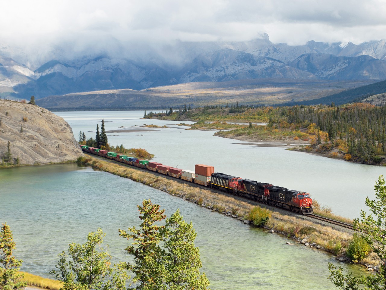 Westbound CN freight rolling along Jasper Lake (Athabasca River), east of Jasper tonwsite. This spot can be reached only on foot, a 50-minute hike on a closed roadway.