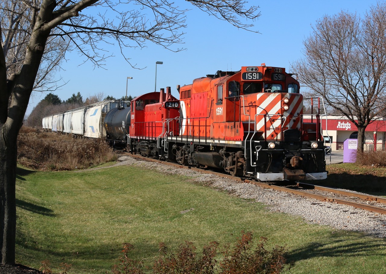The daily Guelph junction Railway (OSR) train between Guelph Jct. and Guelph is seen returning from working the Guelph north spurs. the train stopped briefly to grab some lunch and are seen back under way to guelph yard. Lead unit 1591 is an ex Canadian Pacific GP9u and arrived on the property earlier this year. the trailing SW1200 is former CP as well.