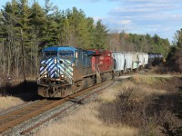 With the skies clearing and the sun rain bowing off its white stripe, CEFX 1044 leads CP 8783 across side road 20 in Puslinch with a small load (approximately 2300 ft) of mostly new tankers, container carriers and hopper cars cleared to Blandford.