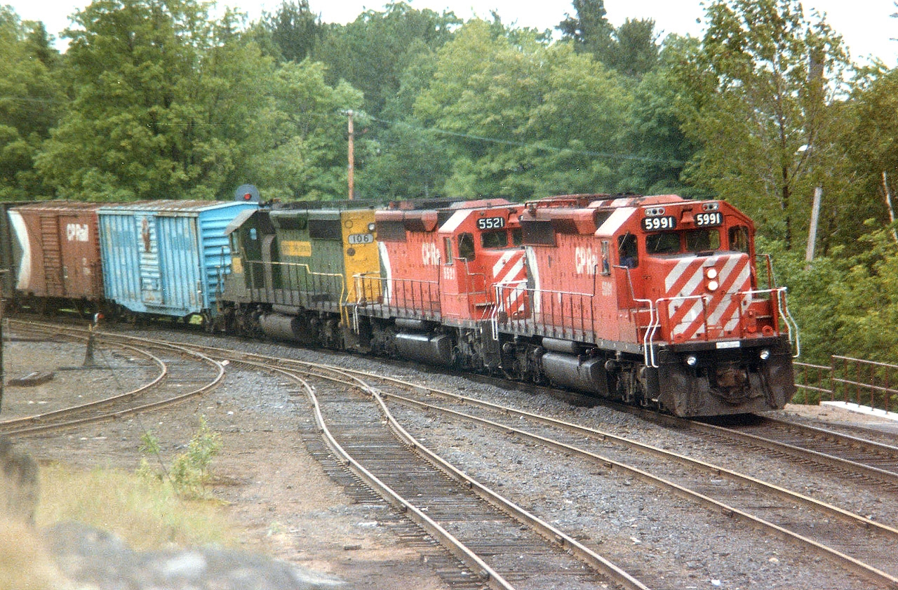 The dullest days bring out the best trains. I had been hanging around Parry Sound station again, hoping to catch something in the "interesting leasers" department, as around this time CP was grabbing any locomotive they could get their hands on. Or so it seemed. I knew there were a handful of Kennecott Copper units roaming around, and couldn't believe my luck actually catching one. And standing on the rocks opposite the station was the best place to be, seeing the unit was third in the consist. Too bad for a very dull windy dark day, it made getting a good sharp image rather difficult. But this shot of CP 5591, 5521 and KCC 106 coming off the big Parry Sound trestle was certainly better than nothing.