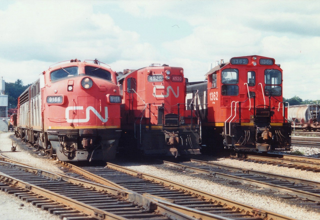 Back when I saw this collection of locomotives waiting out assignments in Hamilton yard, I never forsaw the day when this power would become redundant. I believe there are none of these three models operating any more on CN freight/yard service, save for some rebuilt GP9s.
Just to the right of the recently demolished engine house in the Stuart St yard we see CN 9166 with power for the Nanticoke Steel train, in the middle CN 4520, now in retirement at the Alberta Rail museum, and on the right CN 1362, an SW1200; a series once common all over the system, now extinct.