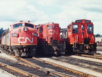 Back when I saw this collection of locomotives waiting out assignments in Hamilton yard, I never forsaw the day when this power would become redundant. I believe there are none of these three models operating any more on CN freight/yard service, save for some rebuilt GP9s.
Just to the right of the recently demolished engine house in the Stuart St yard we see CN 9166 with power for the Nanticoke Steel train, in the middle CN 4520, now in retirement at the Alberta Rail museum, and on the right CN 1362, an SW1200; a series once common all over the system, now extinct.