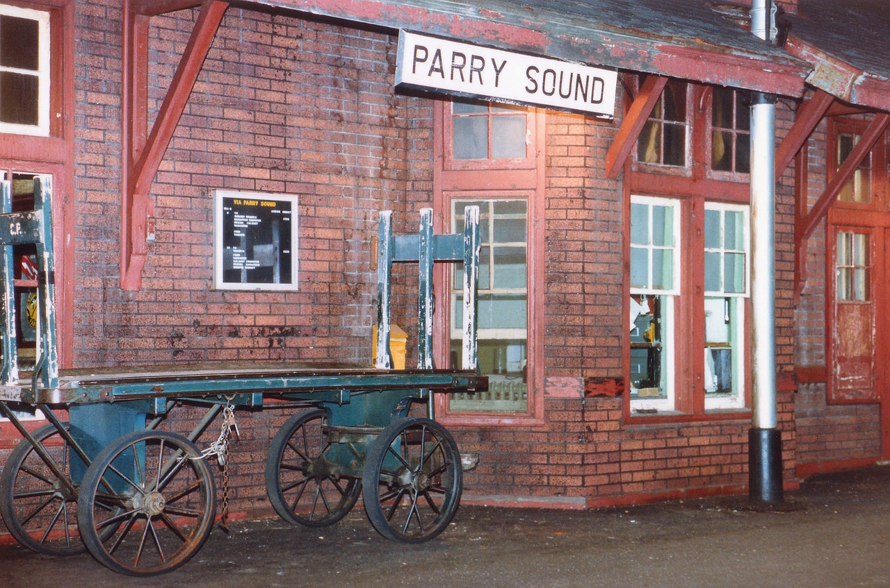 As with the irrepressible Young Mr. Host, I hereby submit image number 500 to the RP.ca site.:o) Sure, it is only a station view, but it holds many memories. I had showed up for the northbound Canadian, and agent Jimmie Bell was such the gracious host that I ended up once again yakking with him well after dark. A southbound with CP 6022 leading was 5 minutes out; it was the eastbound Toronto section of the Canadian VERY late, and I decided to wander out and shoot a night image while waiting to see what other power would be on the train. (CP 6022, VIA 6636,6622; so the VIA leader had crapped out somewhere) Although in 1986 this scene was commonplace (that is, if you could find a station), now it looks like a front in a museum. The only 'modern' improvement was the replacement of the old chalkboard announcing train times. You can see the outline on that cheap, phoney railroad "brick". The station, having been empty for a number of years after the agent was pulled, survived vagrants and druggies and eventually began life anew as an Art Gallery and Gift Shop. (Incidentally, initially I was going to call it quits after 400 submissions to this site but it is like trying to quit trainwatching. It just doesn't happen)