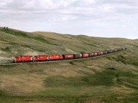 Southbound Fife Lake Subdivision grain spotter bound for Coronach Sask. climbs out of a coulee just to the north of Scout Lake