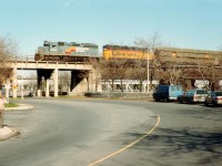 An early afternoon CSX tri-weekly #321 rolls into Canada by way of the now abandoned Steel Arch Bridge spanning the Niagara River. Power is CSX 6352 and 6246; the leader looking spiffy in that old Seaboard paint scheme. It has been a few years, but I believe the photographer on the sidewalk is one Dave Howard, as he appeared before the wife eventually fattened him up. :o) For members of this list who might be curious, as in "Snake", the middle car (Colony Park Wagon) on the right is what I was driving. The Blue machine was down for repairs.