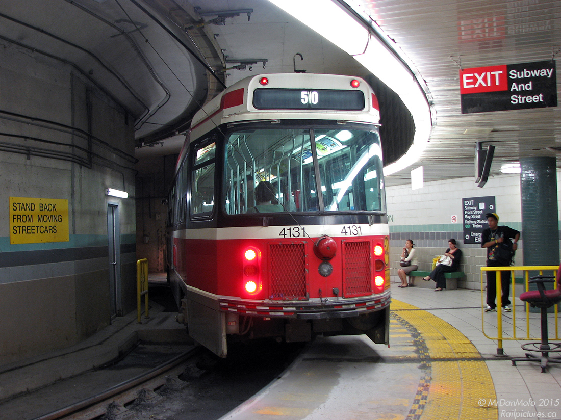 Tight curves and lots of squealing: Toronto Transit Commission CLRV 4131 sits at the loading area of the TTC's underground Union Station streetcar loop after having dropped off a load of passengers (including the photographer) on a southbound 510 Spadina run. The overhead pole is stretched to the extreme, and the yellow line on the platform warns passengers to stay clear of the rear and front overhang swing. The Union Station loop opened in 1990 long after all the surrounding buildings were built, and as a result was shoehorned in with this tight loop to curve around the large underground pillars below Union Station.