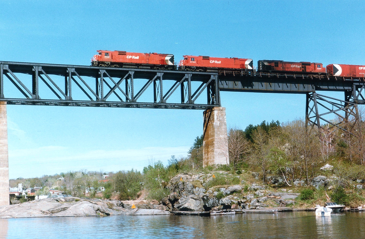I've always subscribed to that old ditty about life being a book of many chapters. One chapter of my days that I wish was a little thicker was the period I spent around Parry Sound. In 1984 I decided this place had some potential (to say the least) and I drove north to the Sound whenever I had a chance up until early 1987 when all of a sudden I started travelling to Kentucky and the remnants of the Southern Rwy. I'm betting Parry is still a great place to shoot trains; but my chapter there closed down rather quickly with the passing of Jimmie Bell, CP Station agent. Without a cozy place to hang out and drink coffee any more, it just wasn't the same. He always provided me with advance notice of anything approaching; and this photo is an example. "Got a 4700 leading, Arnold, and there may be one or two trailing," he probably hollered this day so I took off down to the Town Dock. With the onslaught of SD40s around this time, MLW lashups were not as common as one might think. Here is CP 4741, 4735 and 4553 northbound on a warm spring morning. I'm standing out by the "GULF" fuelling area. I think it is a hangout for seaplanes by that restaurant now.