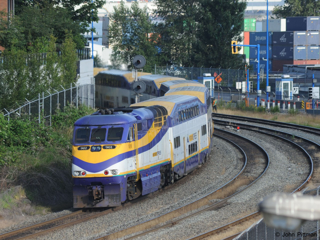 West Coast Express FP59PHi unit 901 pushes a morning trainload of commuters toward the last stop, Vancouver Waterfront Station, about a mile ahead. The engine is lettered WCE 901 but official sources indicate West Coast Express equipment should be BCVX. 
The east end of Vancouver's container port is on the north side of the tracks, to the right.