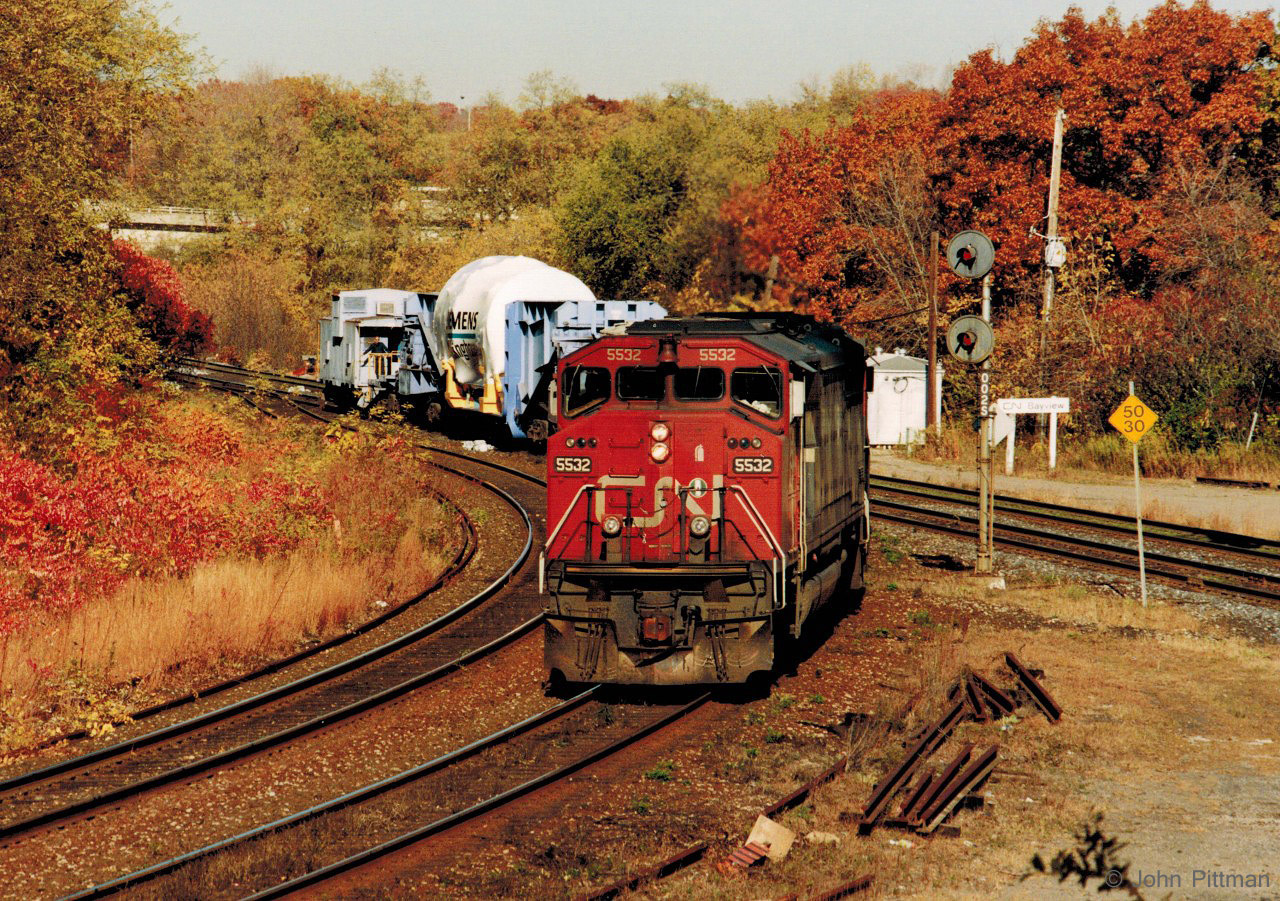 Advance warning of a dimensional Siemens Westinghouse shipment that CN would pick up in daytime in Hamilton, on what looked like a nice autumn day - was enough to persuade me to book the day as vacation and try my luck. 
Many details are forgotten, but the weather and train were as forecast. 
Light CN engines SD60F 5532 and SD40u 6022 were first seen by me westbound at Aldershot West, and found again at Hamilton Stuart Street Yard a bit later. They backed their special train uphill just past Bayview Junction, stopped for the switch and signal, then pulled west on the Dundas sub. 
Last three cars of the train were CN 53398 covered hopper, WECX 102 Schnabel car, and WECX 104 caboose. There may have been more buffer cars.