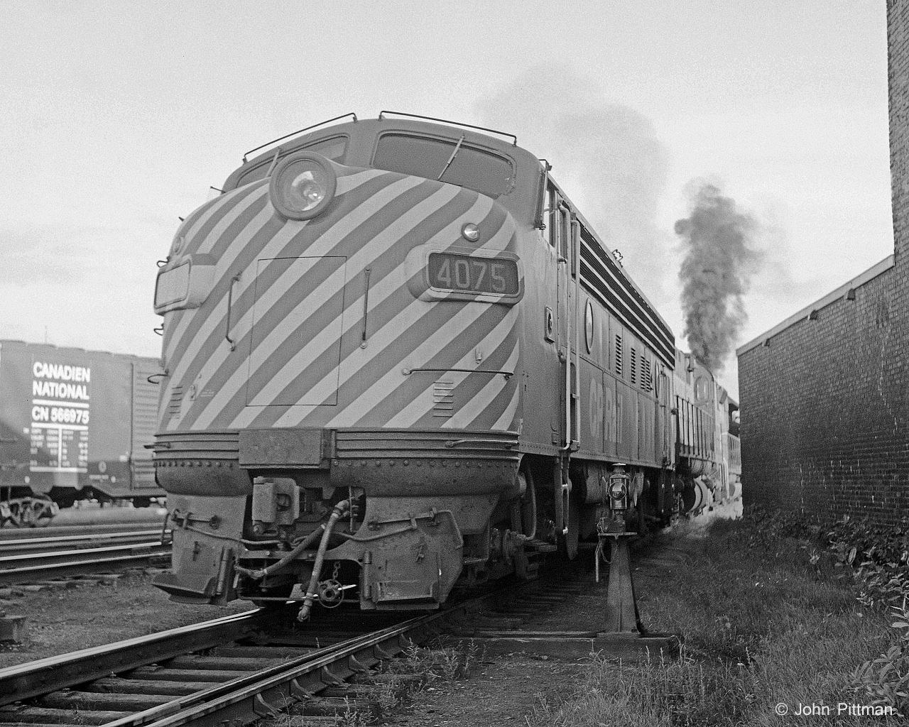 CP 4075, an FP7A, is trailing unit of a consist moving out of the Trois-Rivieres engine track.  Next it will back down onto its train for the return to Montreal.  At this place and time, if you wanted to see an F unit leading, best bet was a CP passenger train. 
Ahead of CP 4075 is a C424 (side mounted bell, round sided fuel tank) and looks like a GP35 in the lead. Quite a lot of smoke for light engines, suspect a heavy hand on the throttle.