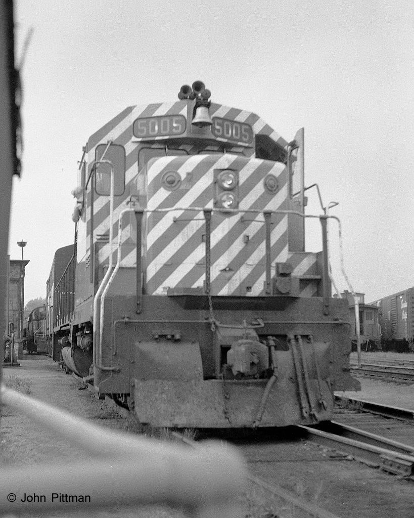 GP35 CP 5005 leads an FB and and RS-3 out of the ready track on its way to lead the afternoon train for Montreal.  The engineer appears to be looking back at the trailing units. 
On the left beside the FB is the refueling stand, while further back the RS-3 is rolling past the corner of the roundhouse.