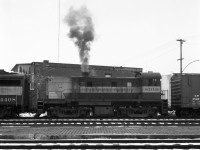 MLW RS-23 CP 8019 is at least the third unit on the afternoon freight returning to Montreal from Trois-Rivieres (since AlCO FB unit 4408 has no cab!). 4-axle power was typical on this run, most often 3 or 4 MLW units with an occasional leading GP-35 or trailing F-unit.  They could have been scraping the bottom of the barrel this day in assigning an RS-23, unless it was working its way back to Montreal for maintenance. CP 8019 was not a regular in T-R yard as I recall. <br>
Looks like the engineer has just throttled up to get the train started.  Much of the traffic was newsprint boxcars loaded at the local paper mills.  