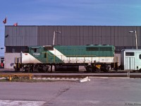 GP40-2(W)  GOT 702 is tied up outside GO Transit's Willowbrook maintence facility this June 1978 weekend, with a train of GO Transit's original single-level coaches.  At the front of the building can be seen another coach and an AMC Gremlin.
This loco was delivered to GO Transit in 1973 as GOT 9810, and was re-numbered GOT 702 in 1975. Unlike GO's previous locomotives (GP40TC), units 700-710 had no Head End Power (HEP) generation for passenger coaches. They were intend to be used with an APCU (GO 900-911) unit at the other end of the train. (Other HEP alternatives being an ex B-unit APU's, or with an HEP equipped locomotive).
Subsequently GO mainly bought HEP equipped locomotives, and the GP40-2(W)'s were sold in 1991, all but one going to CN.  GO 702 became CN 9670; the ex-GO units ran in Green and White paint on CN for a while. 