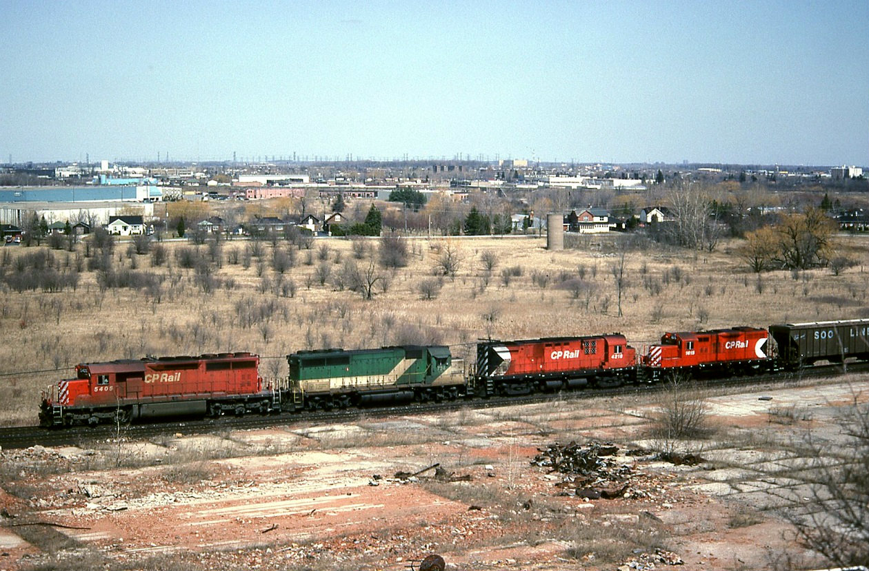 Seen from a pile of old tailings of the former brick works to the west of Milton. CP train 923 starts its climb along the Niagara escarpment. . The GP9 trailing was headed to London for yard service.