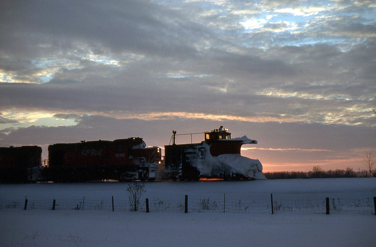 After starting in the early hours, the crew of the plow extra is calling it a day as the sun fades away fast to the west. But it was not to be as the plow would derail on a broken rail about a mile north. Cold and hungry after chasing the plow all day, we never did hear the out come.