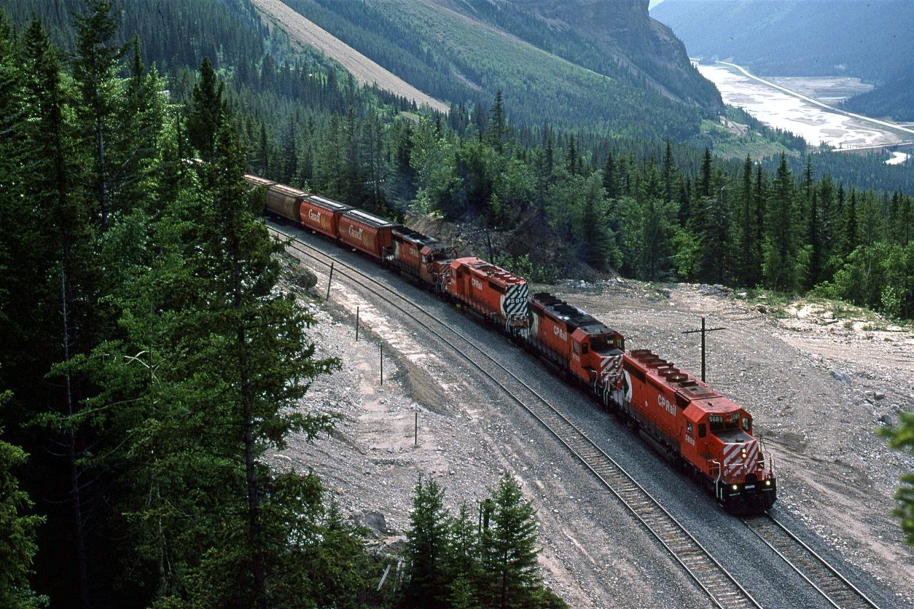 From the same vantage point as the previous picture, the eastbound manifest has cleared both spiral tunnels and it by Partridge siding.
In the background, can be seen the tracks as they hug the side of Cathedral Mountain as they descend into Field.