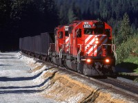 My note call this Flat Creek. This is where the new MacDonald Tunnel will emmerge on the west side of Rogers Pass. The construction of new track bed is evident to the left.
Coal empties are working up hill.
