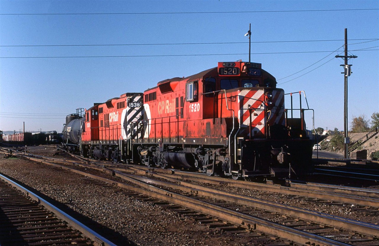 !520 and 1536 are working the east end of the hump classification tracks, assembling a train for departures elsewhere. The tracks on the ridge at far right, with the wooden stairway, are the CN connecting tracks from their facility (Sarcee Yard) to CP's Alyth Yard.