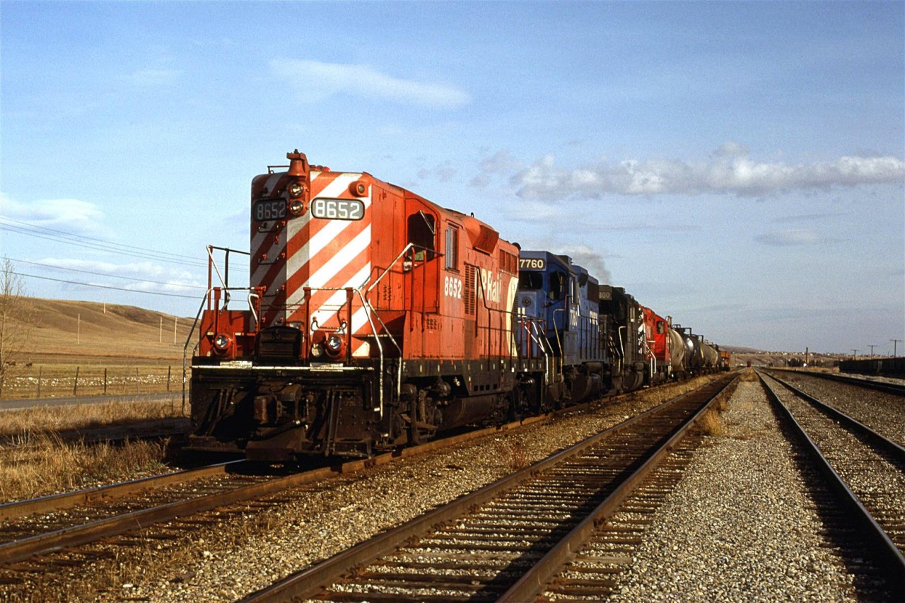 This is the same Exshaw turn pictured crossing the Bow River, but now it is at Kieth Yard. It appears to have dropped the bulkhead flat full of what looked like raw ties in the yard in the background. It then picked up a few tank cars. 
Obviously, the RR's weren't quite as protective of their property back then when common sense and personal responsibility were more prevalent.