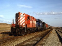This is the same Exshaw turn pictured crossing the Bow River, but now it is at Kieth Yard. It appears to have dropped the bulkhead flat full of what looked like raw ties in the yard in the background. It then picked up a few tank cars. 
Obviously, the RR's weren't quite as protective of their property back then when common sense and personal responsibility were more prevalent.