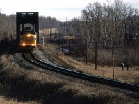 The westbound "Canadian" crosses the Bow River using two bridges in west Calgary. A couple of onlookers watch from a distance.