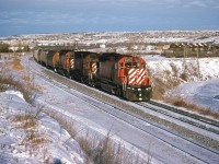 It is cold, but sunny in Calgary on this Mid-December day. There appears to be no warming chinook winds. The folks on the eastbound CP grain train probably think that I am nuts.
This is Brickburn siding and beyond is a frozen Bow River.
